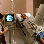 Radiographer conducts barium meal X-ray on a woman